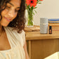 Woman sitting at a desk with a vase of flowers and a doTERRA Pilot Diffuser with Endless Summer Blend