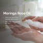 Person applying Moringa Rose Oil to their hand with product details displayed.