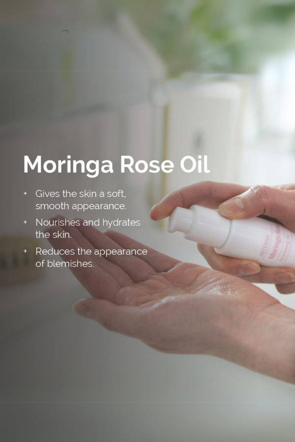 Person applying Moringa Rose Oil to their hand with product details displayed.