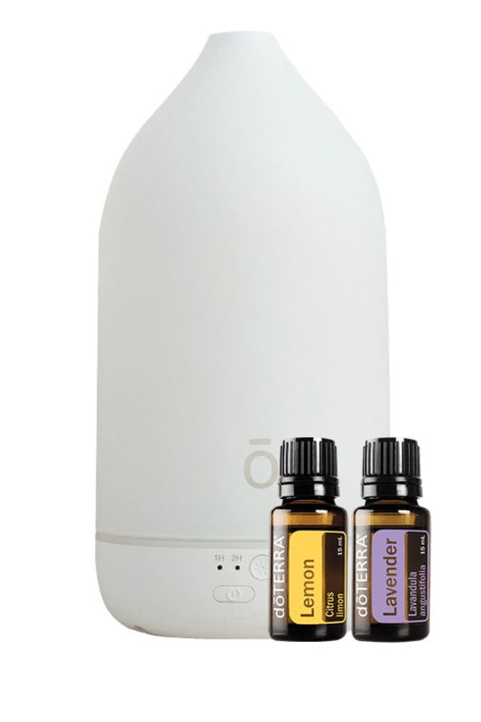 A white diffuser bottle with two small essential oil bottles labeled Lemon and Lavender, shown on a clean white background. dōTERRA Laluz Diffuser with Lemon and Lavender